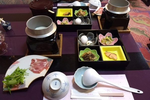 On the righ are small plates with pickles, fish and an egg that has been soft boiled in onsen waters - it should be cracked over some rice. On the left, soy milk in which the ham and greens are cooked. You also drink the milk. Missing in the picture are a bowl of rice and miso soup.